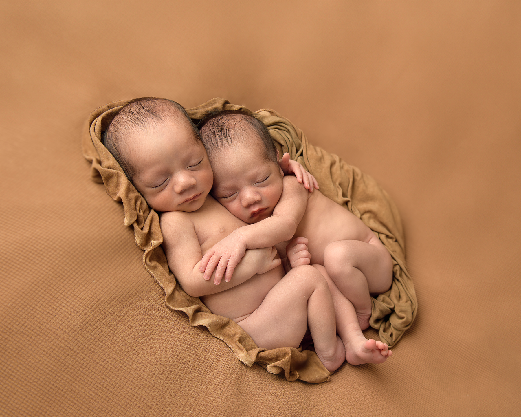 Newborn twin boys sleeping together